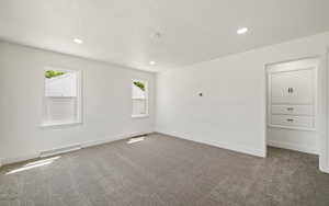 Carpeted empty room with recessed lighting, plenty of natural light, baseboards, and a textured ceiling