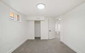 Basement featuring carpet and baseboards