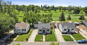 Aerial view of residential area featuring a tree filled landscape and a local golf course