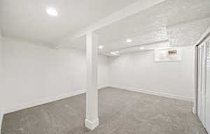 Basement featuring carpet flooring, a textured ceiling, recessed lighting, and baseboards