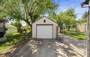 Detached garage with asphalt driveway and a gate