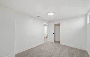 Carpeted empty room with baseboards