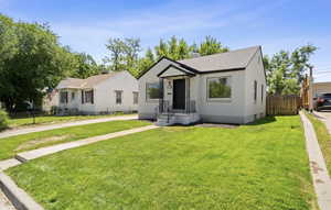View of front facade with stucco siding, concrete driveway, and roof with shingles