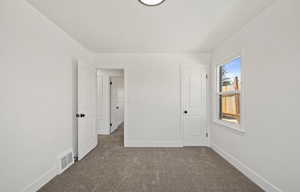 Unfurnished bedroom with carpet and baseboards