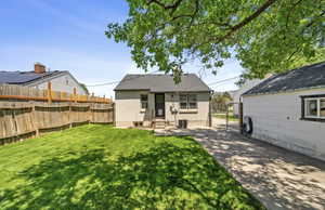 Rear view of house with stucco siding and entry steps