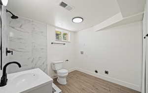 Full bathroom featuring toilet, a textured ceiling, a shower, vanity, and baseboards