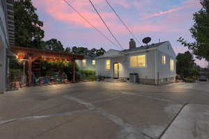 Rear view of house with a chimney, a pergola, a patio, entry steps, and central AC unit