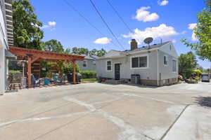 Back of property with a chimney, a pergola, a patio, and central AC unit