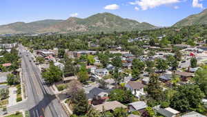 Aerial view of property and surrounding area with a mountainous background and nearby suburban area