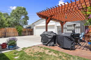 View of patio featuring a garage and a pergola