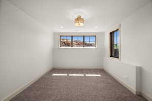 Carpeted spare room featuring baseboards
