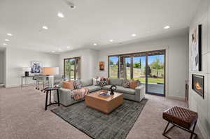 Living area with recessed lighting, carpet flooring, a fireplace, and baseboards