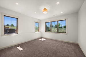 Carpeted empty room with healthy amount of natural light, recessed lighting, and baseboards