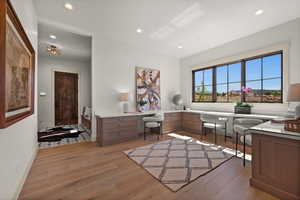 Office space featuring light wood finished floors, recessed lighting, and baseboards