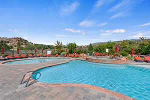 Community pool with a patio area and a mountain view