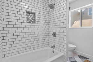 Full bathroom with toilet, baseboards, shower / washtub combination, and marble finish floors