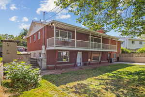 Back of property featuring brick siding, a chimney, and central AC