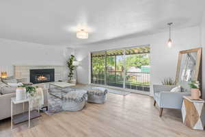 Living area featuring wood finished floors and a stone fireplace