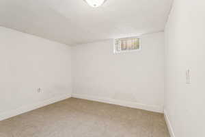 Basement with light carpet and baseboards