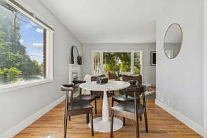 Dining area featuring wood finished floors and a fireplace