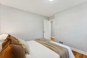 Bedroom with wood finished floors and baseboards