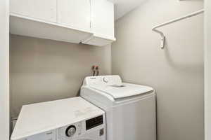 Washroom featuring cabinet space and washer and dryer