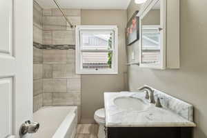 Full bathroom with toilet, vanity, shower / tub combination, and wood finished floors