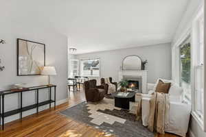 Living area featuring wood finished floors and a glass covered fireplace