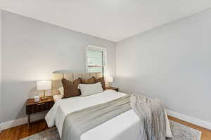 Bedroom featuring baseboards and wood finished floors