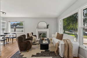 Living area with wood finished floors and a warm lit fireplace