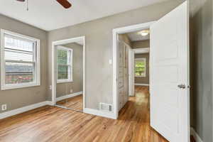 Unfurnished bedroom with baseboards, light wood-style flooring, a closet, and ceiling fan