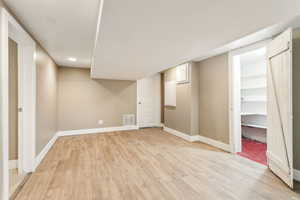 Finished below grade area featuring light wood finished floors, baseboards, and recessed lighting