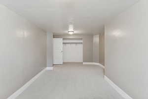 Finished below grade area featuring light carpet and baseboards