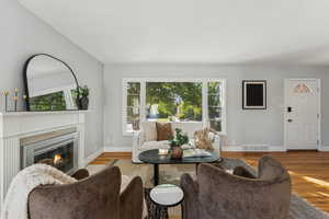 Living area with a glass covered fireplace and wood finished floors