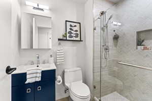 Hall Bathroom with vanity, toilet, and a shower stall