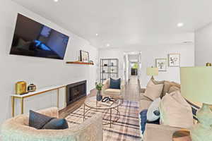 Living room featuring recessed lighting, wood finished floors, a fireplace, and baseboards