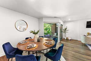 Dining room with baseboards, wood finished floors, and recessed lighting