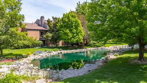 View of grassy yard featuring a garden pond