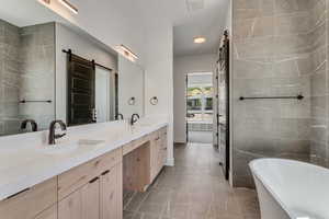 Primary Bathroom featuring dual sinks, soaking tub and separate shower and water closet