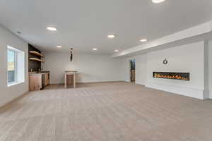 Basement family room with optional fireplace, baseboards, recessed lighting, and optional bar