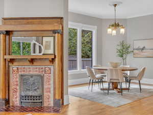 The fireplace is a stunning centerpiece, with a richly carved wood mantel, intricate tile work, and original iron detailing; all beautifully preserved from the late 1800s.