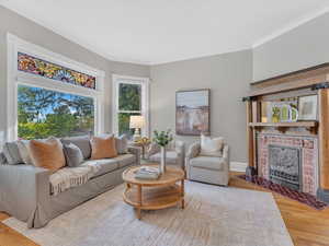 The expansive living room floods with natural light, its broad windows overlooking the elevated corner lot and framing sweeping, picturesque views of the neighborhood.