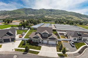 Aerial view of property and surrounding area featuring a mountain backdrop