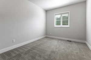 Carpeted empty room featuring baseboards