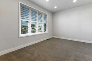 Unfurnished room with recessed lighting, dark carpet, and baseboards