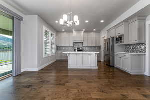 Kitchen with stainless steel appliances, light countertops, tasteful backsplash, a chandelier, and recessed lighting