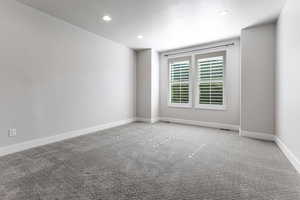 Carpeted spare room featuring recessed lighting, baseboards, and a textured ceiling