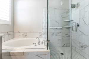 Full bath featuring a bath and a stall shower