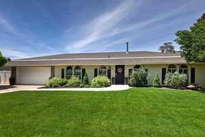 Ranch-style home featuring brick siding, concrete driveway, an attached garage, and roof with shingles