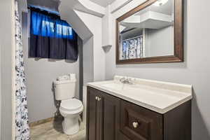 Full bath with toilet, vanity, wood finished floors, and a shower with shower curtain